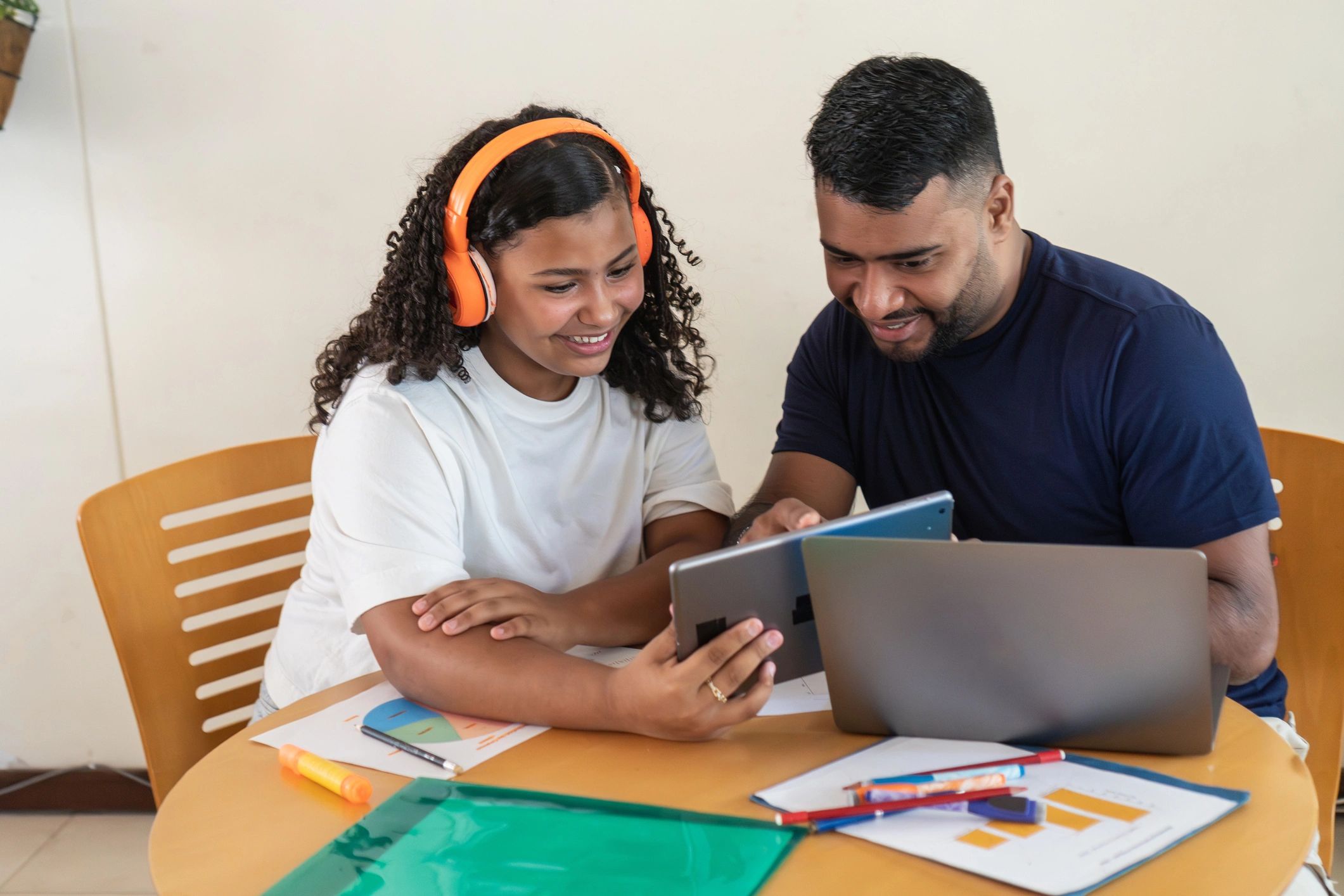 Father and daughter learning together with digital devices