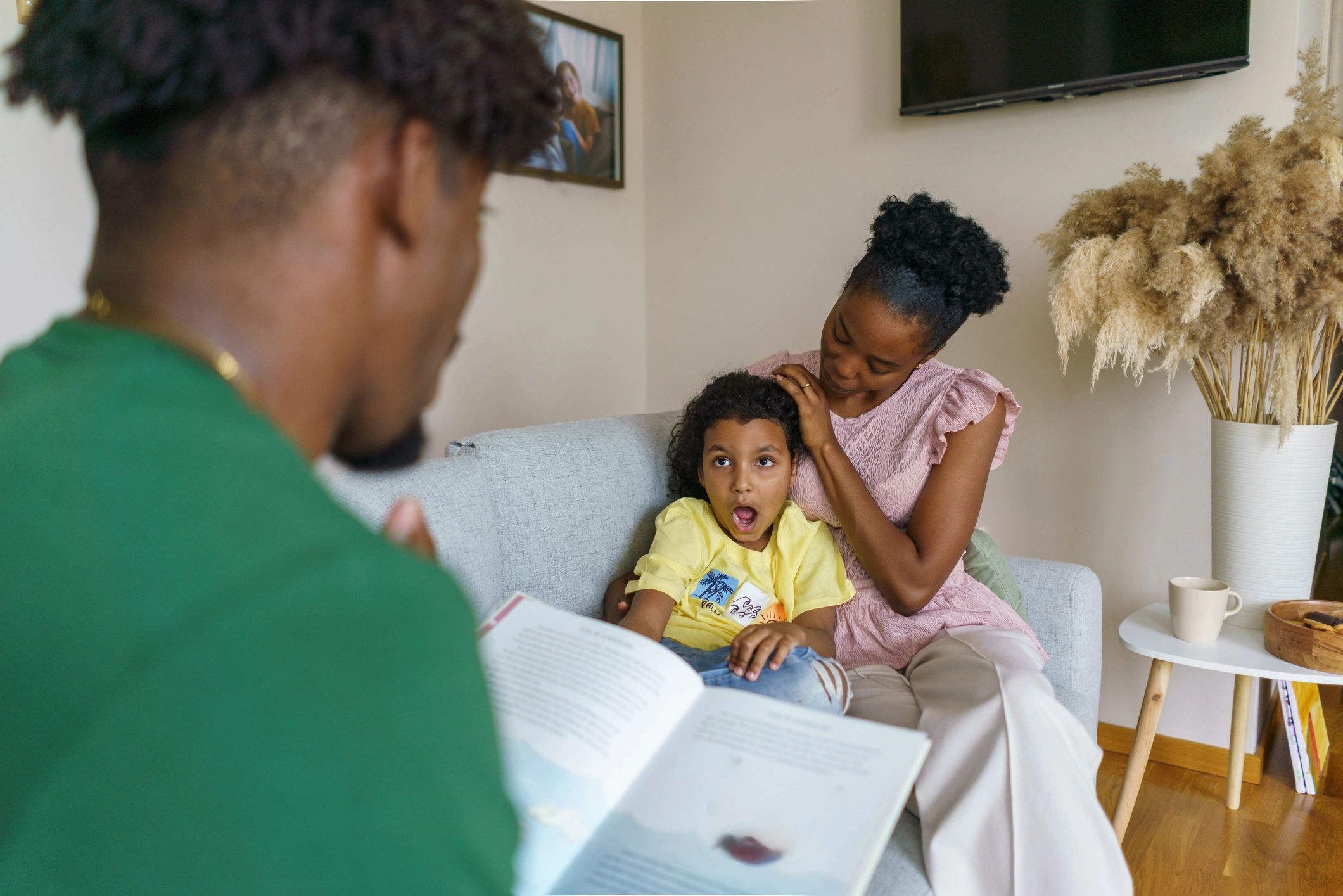 Family sharing a book together at home